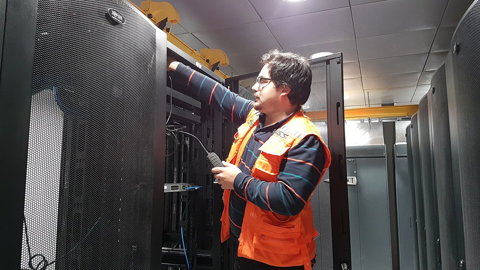 Technician connecting cables in a server rack