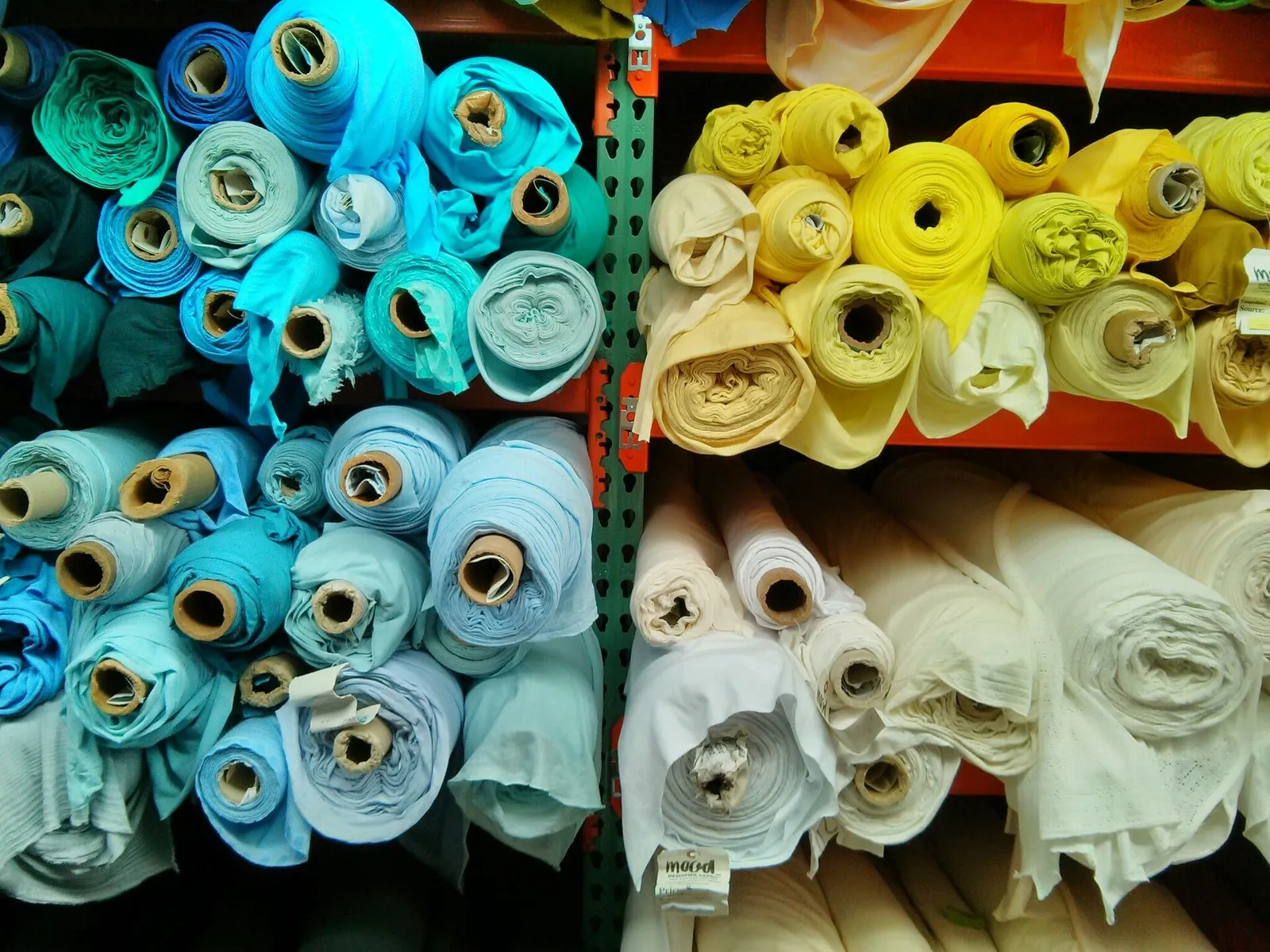 Colourful fabric rolls stacked on shop shelves